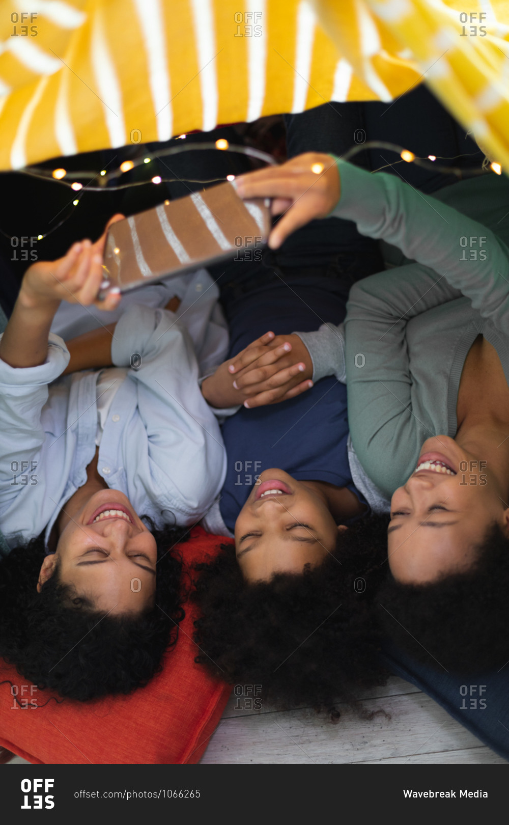 Happy Mixed Race Lesbian Couple And Babe Lying Down Using Smartphone Stock Photo OFFSET