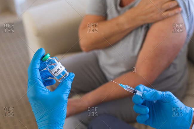 Hands of doctor preparing covid19 vaccination for senior woman