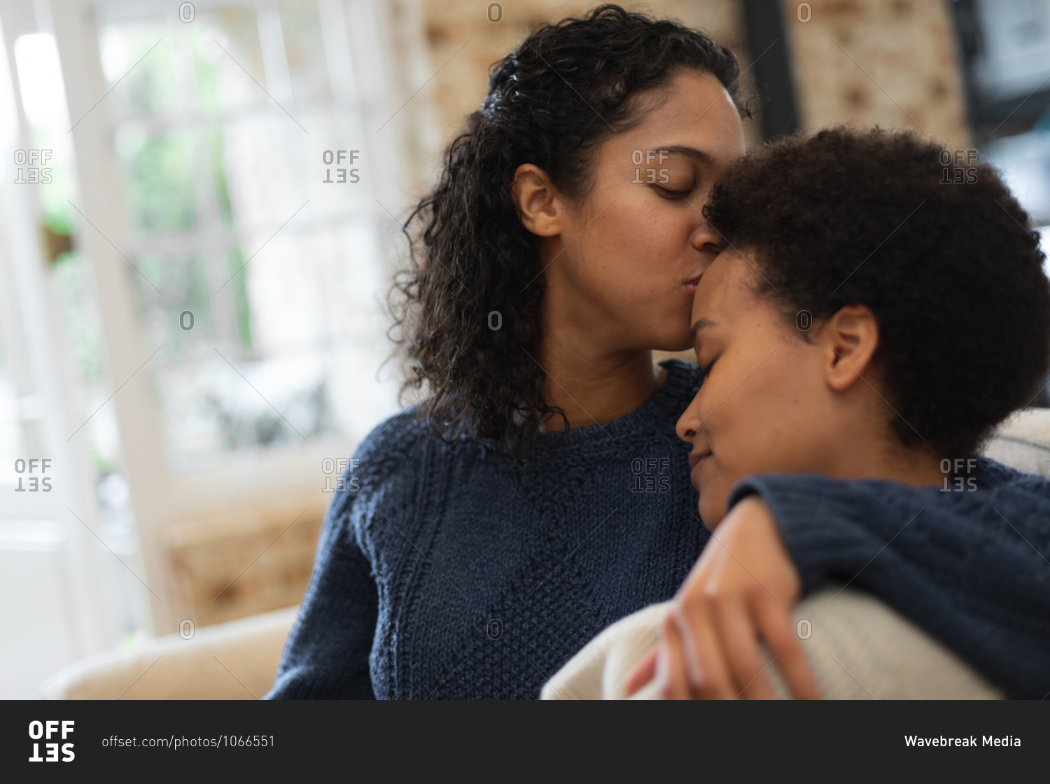 Mixed Race Lesbian Couple Kissing On Forehead In Kitchen Stock Photo OFFSET