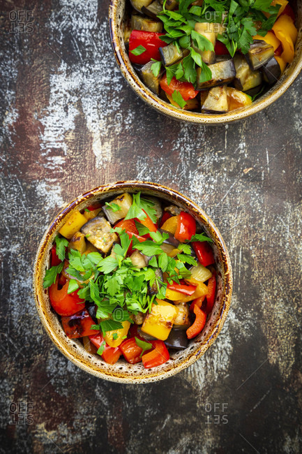 Two bowls of grilled eggplants and bell peppers with parsley