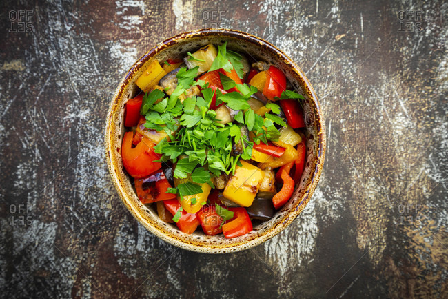 Bowl of grilled eggplants and bell peppers with parsley