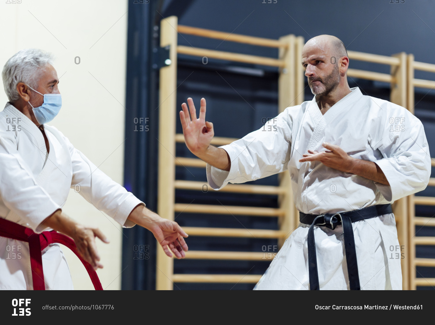 Male student practicing karate by instructor in class