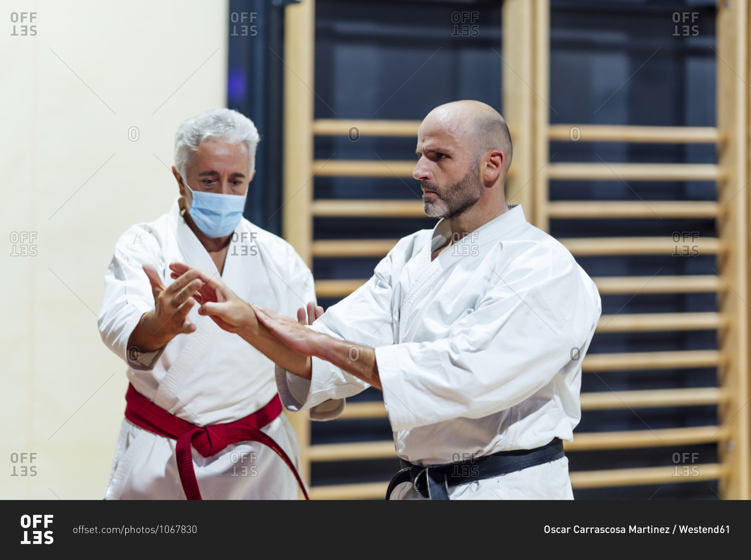 Instructor teaching karate to male student in class