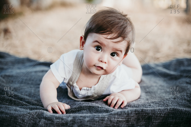 Cute baby crawling on blanket outdoors