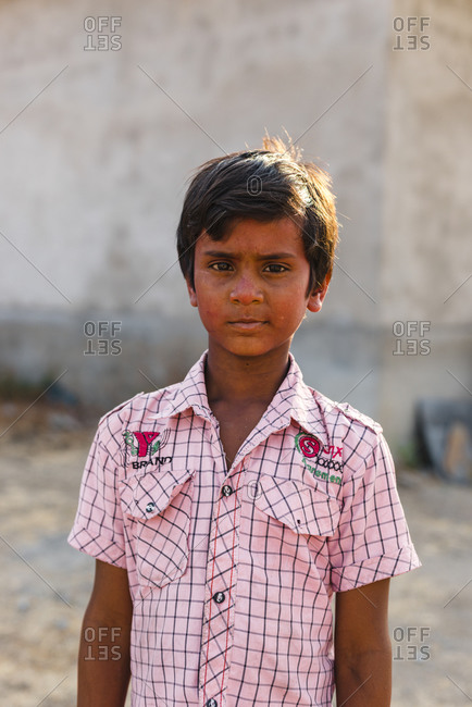 Hampi, Karnataka, India - April 07, 2019: Proud Indian young boy wearing pink plaid shirt