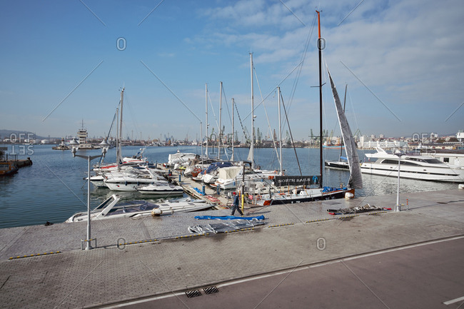 Varna, Bulgaria - November 16, 2020: A man walking in front of yachts anchored at a marina Port of Varna which is the largest seaport complex in Bulgaria