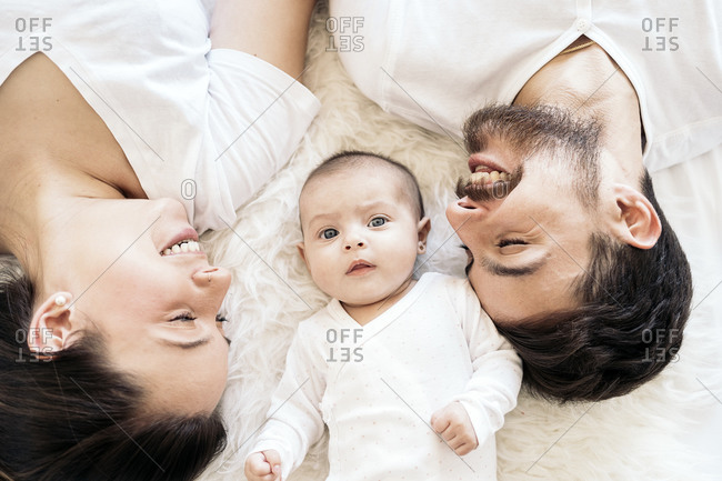 Happy And Young Parents Lying In Bed With Their Young Baby In Spain Stock Photo Offset