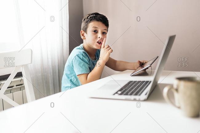 Cute boy using tablet while sitting in the living room in Spain
