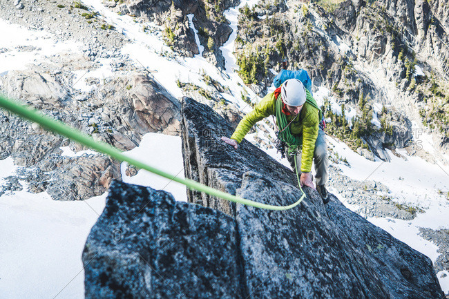 Rock climbing man climbing on mountain in Washington with rope