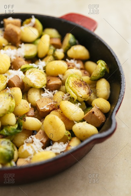 Gnocchi with brussels sprouts and vegan hot dog pieces in a pan