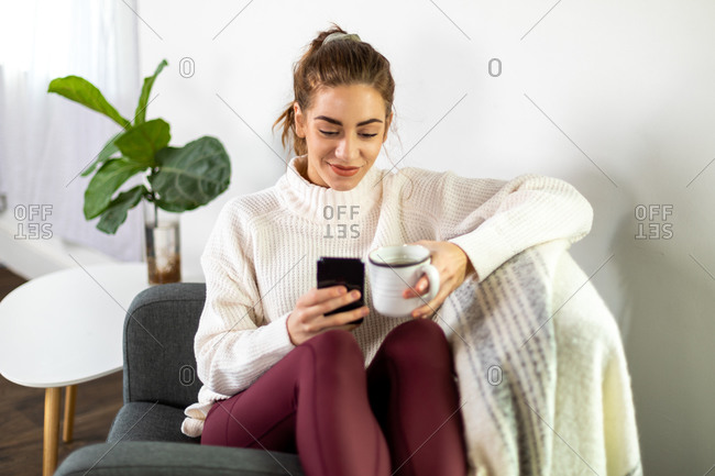 Woman holds her mug and texts