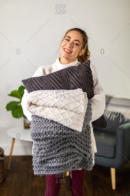 Woman holds blanket and pillows