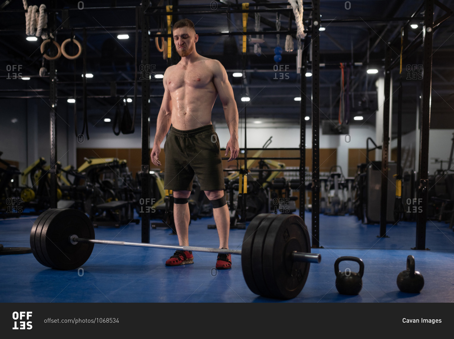 Aggressive sportsman ready to exercise with barbell