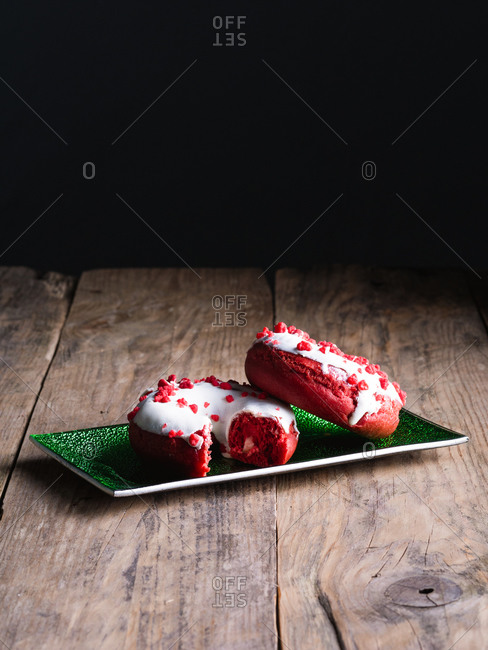 Doughnuts on a green tray isolated on wooden and black background