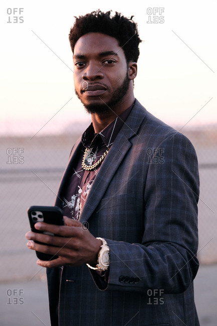 African American business man checking phone at sunset