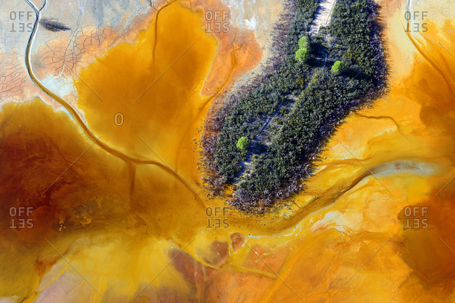 Aerial view of small green patch of terrain surrounded by brown acids of Rio Tinto Mines area