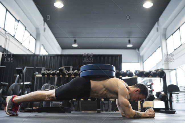 Male athlete doing plank position in health club