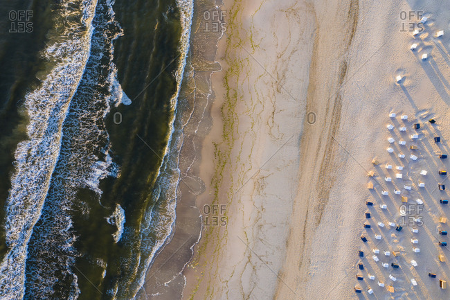 Aerial view of hooded beach Chairs on sandy coastal beach