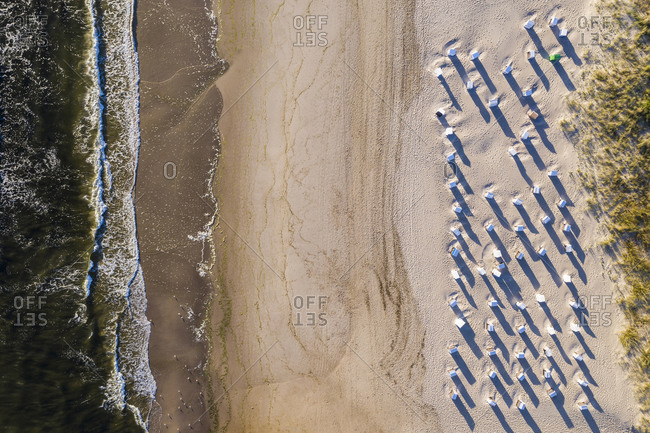 Aerial view of hooded beach chairs on sandy coastal beach