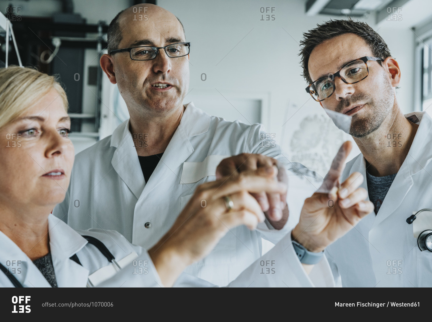 Scientists discussing about human brain slide while standing at laboratory