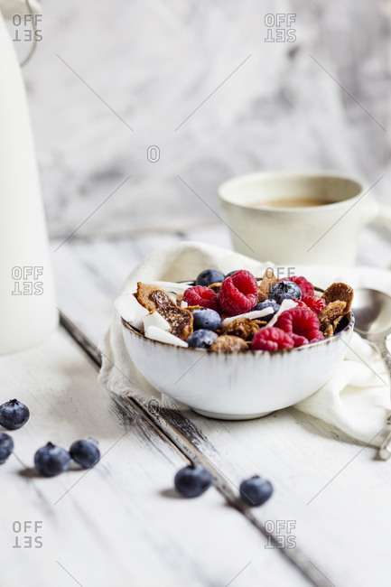 Bowl of homemade cereals with coconut- raspberries and blueberries