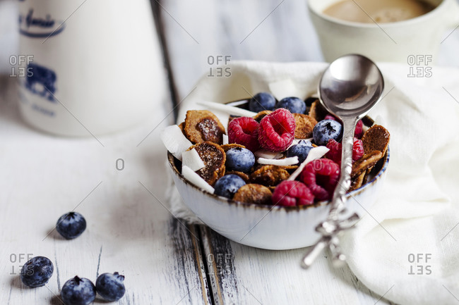Bowl of homemade cereals with coconut- raspberries and blueberries