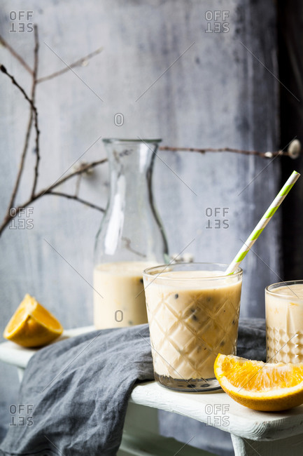 Glasses of fresh fruit smoothie with oranges- bananas- yogurt and grenadine