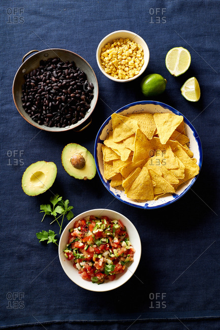 Ingredients for cooking chilaquiles - black beans, tortilla chips, corn and salsa