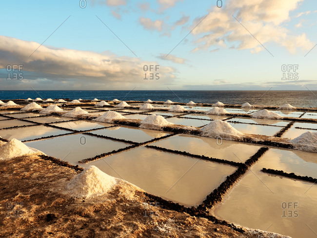 Amazing scenery of salt flats located near sea at sunset in La Palma in Spain