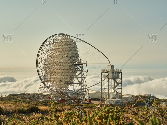Amazing view of modern telescopes on dark mountaintop against cloudy sky at astronomical observatory on island of La Palma in Spain