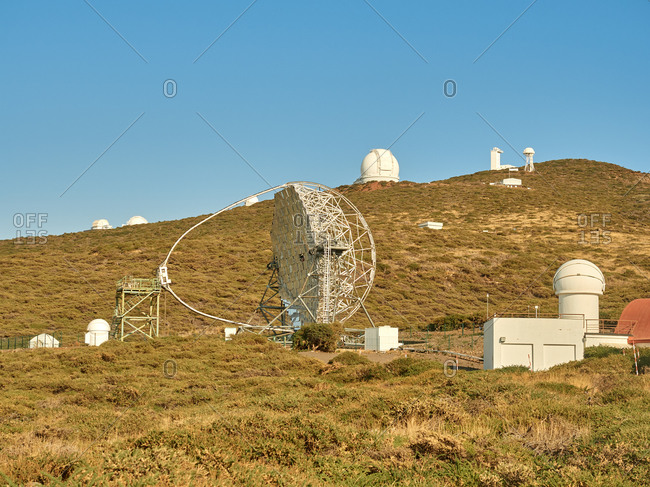 Various modern telescopes including MAGIC or Major Atmospheric Gamma Imaging Cherenkov Telescope located on hill slope at astronomical observatory on island of La Palma in Spain