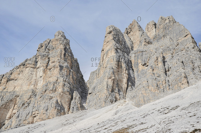 Amazing view of snowy mountains and valley in Dolomites on blue sky with clouds