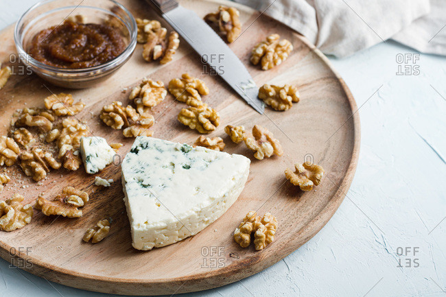 Top view of appetizing blue cheese and walnuts prepared on wooden board in kitchen for cooking tasty homemade cheesecake