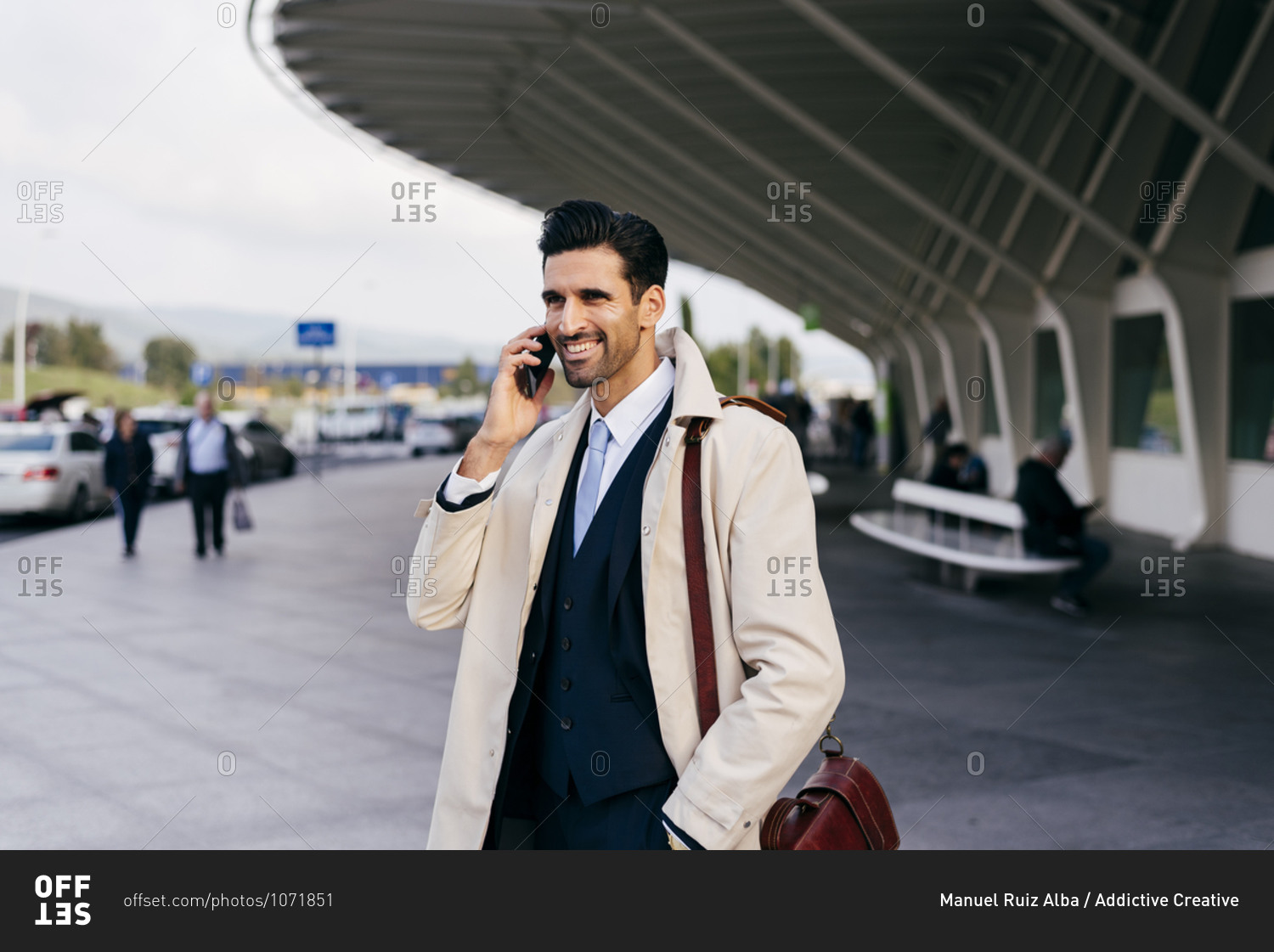 Busy man with dark hair in suit and coat speaking on phone
while standing near airport terminal at daytime stock photo -
OFFSET