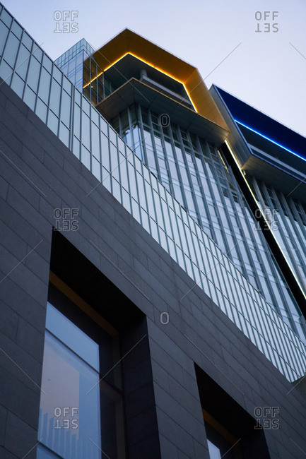 Close-up of modern building with glass windows, gloomy sky in afternoon