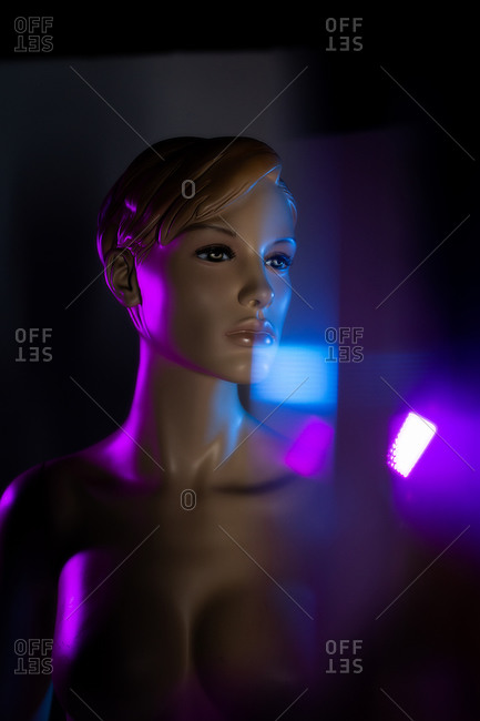 Creative image of mannequin woman in dark room with light effects