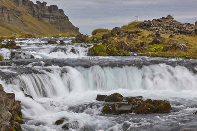 A classic Icelandic landscape, a river flowing along the base of a cliff, The Fossalar River, near Kirkjubaejarklaustur, Iceland, Polar Regions