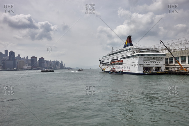 Hong Kong, China - September 23, 2016: View of a big ferry anchored at the port of Hong Kong with a view of the city's skyline at the Central Ferry Piers