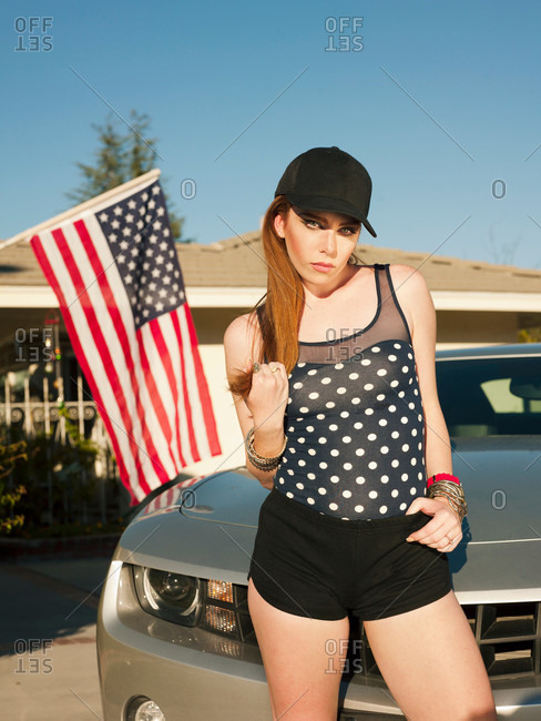 Woman standing by car in driveway