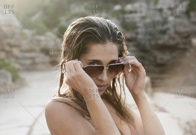 Portrait of young woman looking over her sunglasses