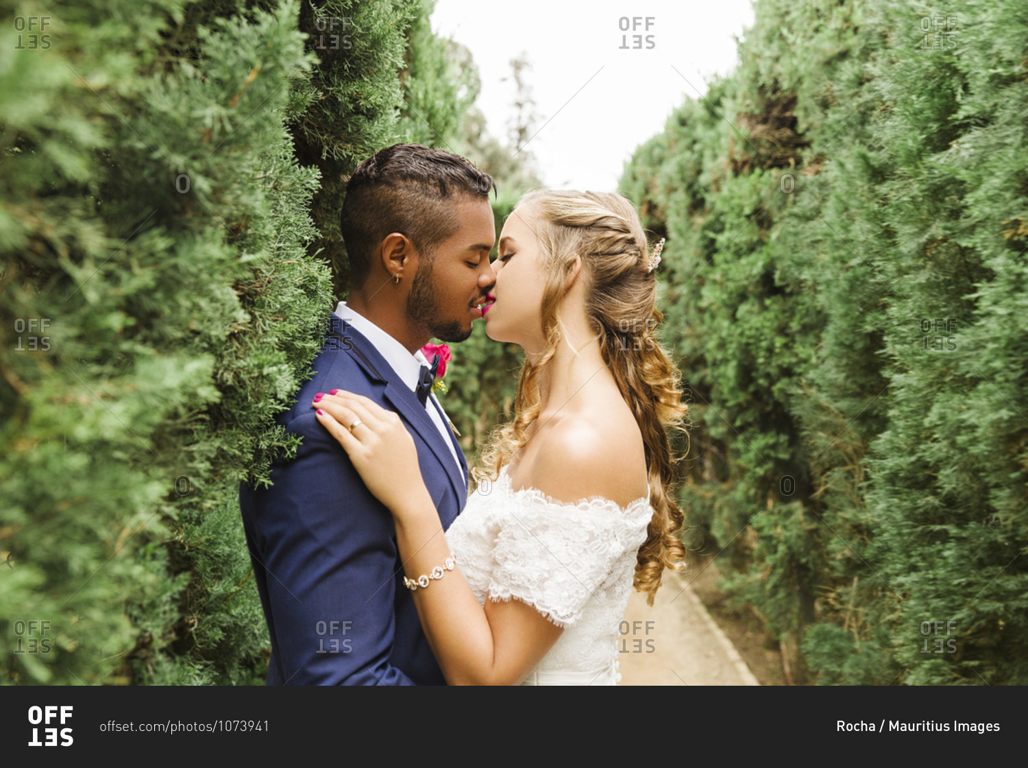 Wedding, newlyweds, young adults, diversity, love, garden, hedge, kissing
