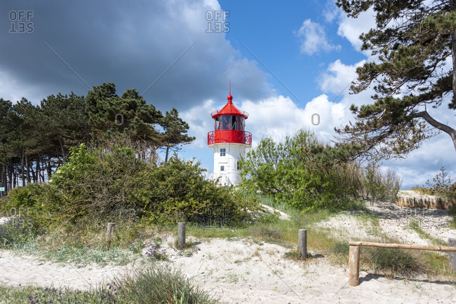 Germany, mecklenburg-west pomerania, hiddensee, old lighthouse gellen on a grass dune. sunny summer day. beautiful blue sky with clouds in the background, baltic sea.