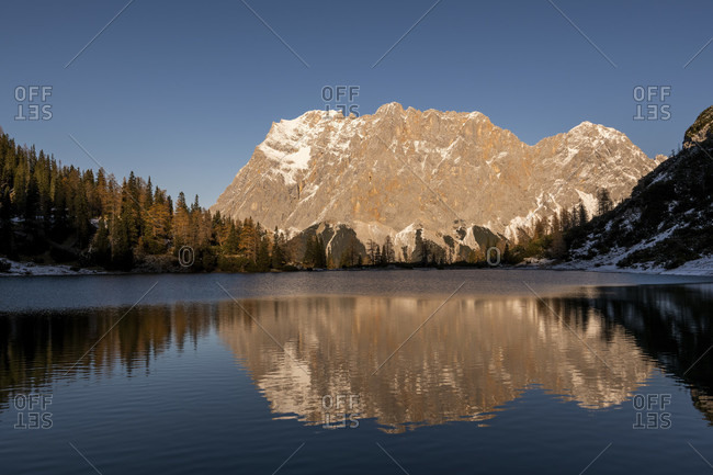 The wetterstein mountains with zugspitze are reflected in the clear water of the seebensee near the tyrolean hut