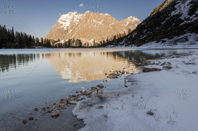 On the banks of the seebensee in tyrol, with a view of the wetterstein mountains / zugspitze in winter