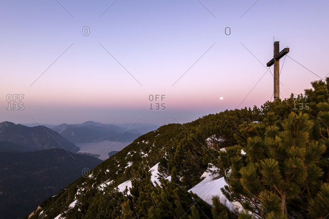 Simetsberg summit cross and in the background karwendel, walchensee and estergebirge with full moon in the evening after sunset