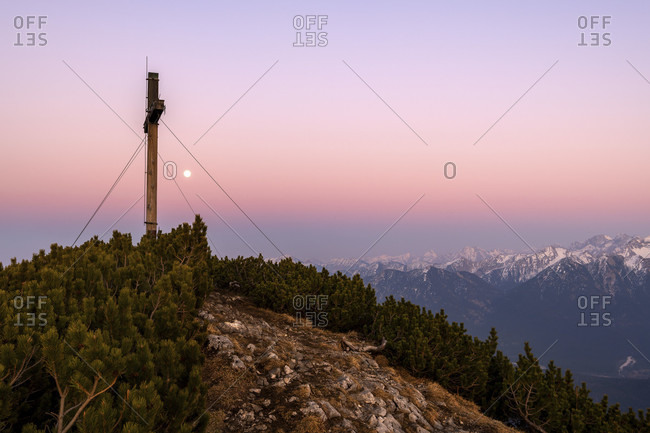 Simetsberg summit cross and in the background karwendel and estergebirge with a full moon in the evening after sunset