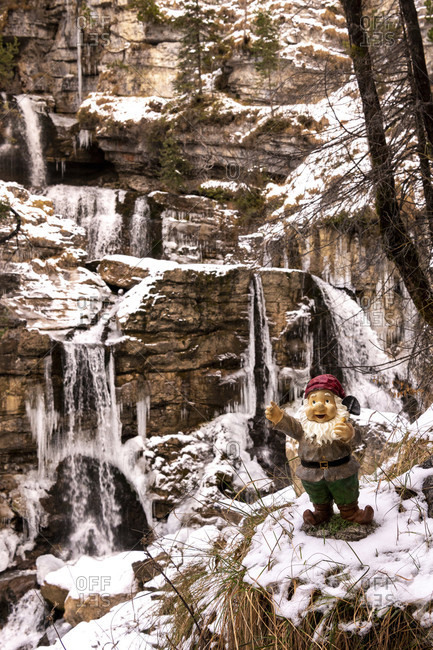 A runaway garden gnome stands in the snow at the kuhflucht waterfalls near farchant. how he got there remains a mystery.