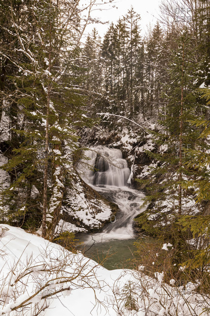 Waterfall of the obernach canal between wallgau and the walchensee in the bavarian prealps in winter with snow
