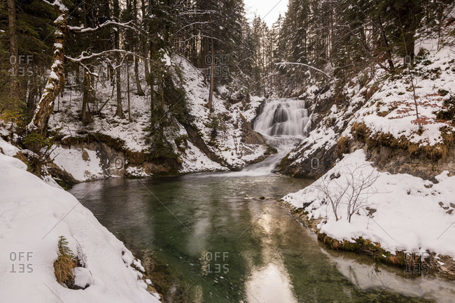 Waterfall of the obernach canal between wallgau and the walchensee in the bavarian prealps in winter with snow