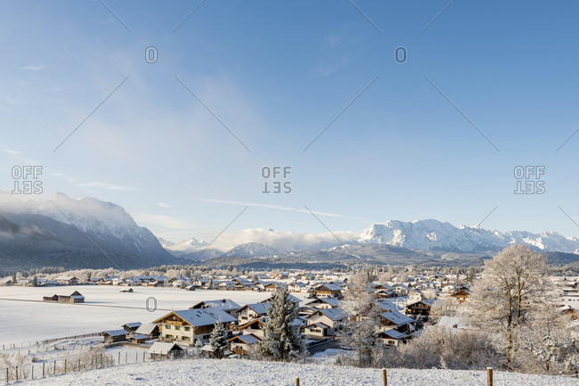 View of the snow-covered village of wallgau in the bavarian alps in winter with fresh snow and a blue sky